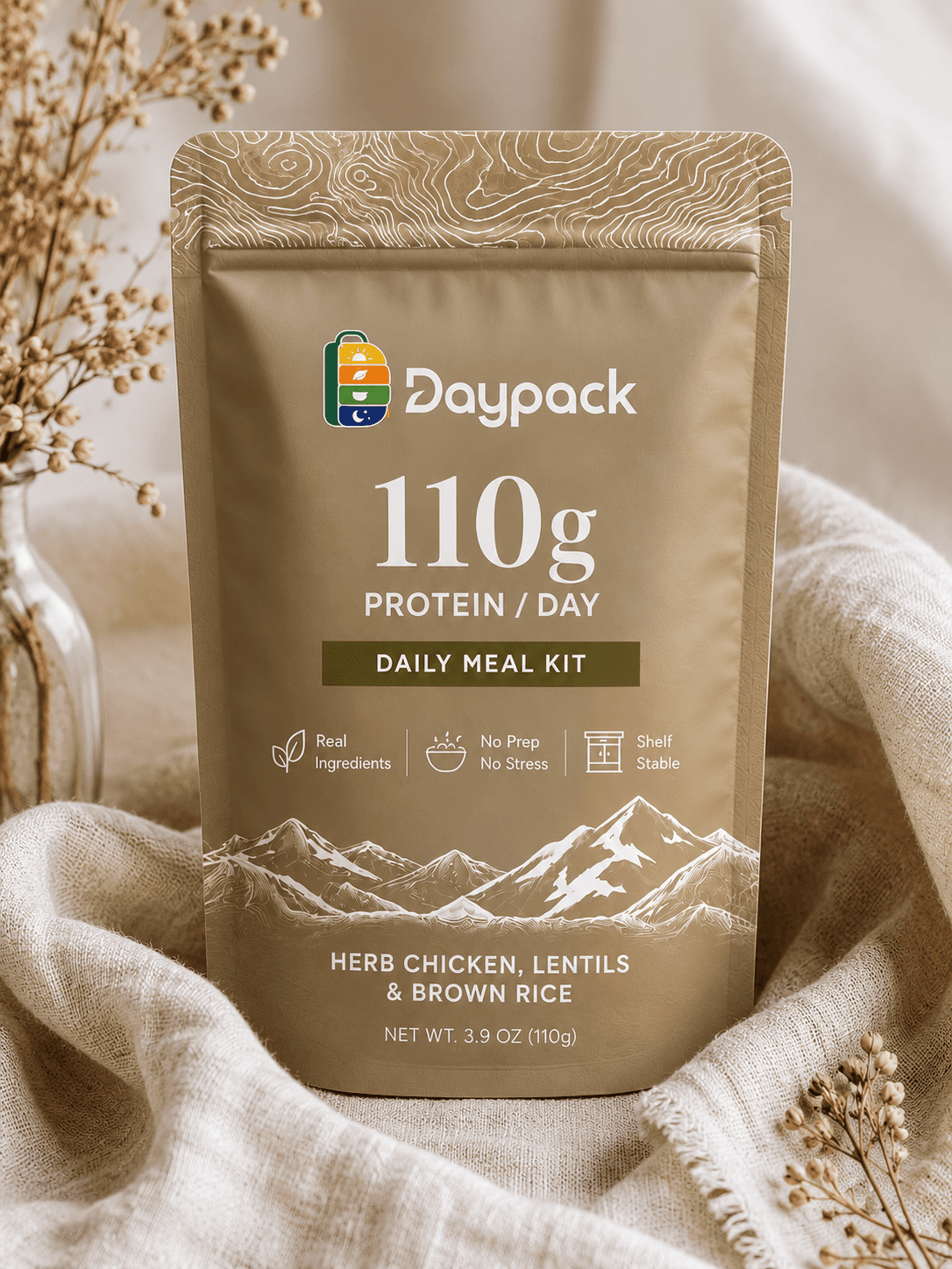 Daypack 110g daily meal kit pouch in tan linen against dried botanicals and a soft linen drape.